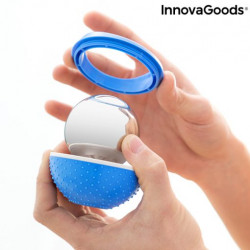Manos abriendo la base azul de la bola masajeadora InnovaGoods para extraer la esfera de acero