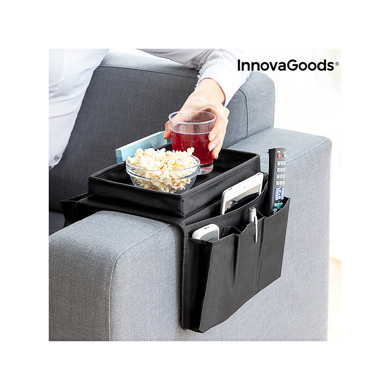 Mujer usando bandeja reposabrazos de sofá InnovaGoods negra con bol de palomitas, vaso y mandos