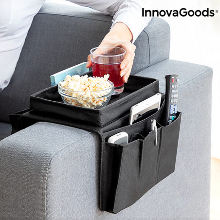 Mujer usando bandeja reposabrazos de sofá InnovaGoods negra con bol de palomitas, vaso y mandos